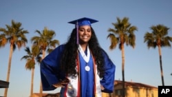 Harvard-bound Abia Khan, valedictorian of her high school class and the daughter of immigrants from Bangladesh, poses in her cap and gown in Laveen, Arizona, on May 5, 2020.