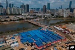 FILE - An aerial view shows a construction site for coronavirus isolation facilities and a temporary bridge linked China's Shenzhen and Hong Kong's Lok Ma Chau cities in Hong Kong, March 11, 2022.