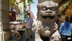 People make their way past the Dragon Gate southern entrance to Chinatown in San Francisco, May 23, 2022.