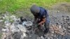 Experto en explosivos extrae fragmento de misil ruso en el territorio del Monumento a las Víctimas del Totalitarismo en las afueras del norte de la ciudad ucraniana de Járkov, el 8 de mayo de 2022. (Foto de SERGEY BOBOK / AFP)