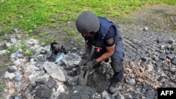 Explosives expert extracts fragment of Russian missile on the territory of the Memorial to the Victims of Totalitarianism on the northern outskirts of Ukrainian city of Kharkiv, on May 8, 2022.