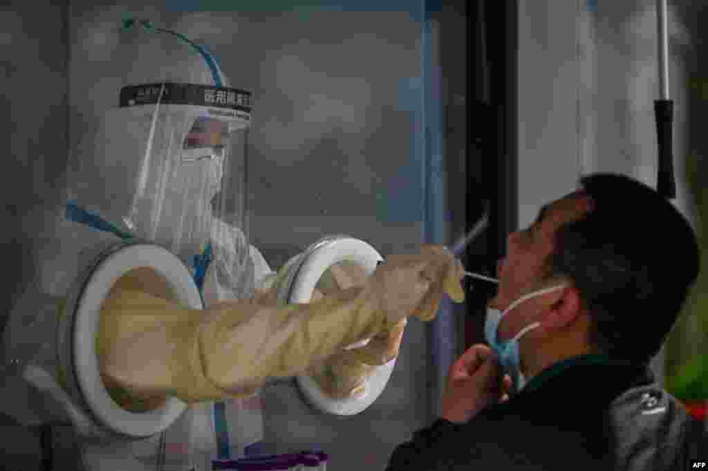 A health worker takes a swab sample from a man during a COVID-19 lockdown in the Jing'an district in Shanghai, China.