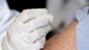 ARCHIVO. La Dra. Marcia Trape del Centro de Salud de la Universidad de Connecticut empuja la aguja de inmunización de la vacuna contra la viruela quince veces en el brazo del Dr. Richard Garibaldi frente a los medios de comunicación el 24 de enero de 2003 .