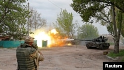 Service members of pro-Russian troops fire from a tank during fighting in Ukraine-Russia conflict near the Azovstal steel plant in the southern port city of Mariupol, Ukraine May 5, 2022.