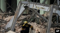Um membro de uma equipa de resgate procura por sobreviventes no local de uma explosão mortal que destruiu o hotel de cinco estrelas, Saratoga, em Havana, 6 de Maio, 2022.