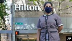 Sonia Guevara poses for a photo, May 18, 2022, outside the Hilton hotel where she works as a housekeeper in downtown Seattle.