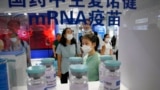 Visitors look at giant replica bottles of COVID-19 vaccine using mRNA technologies at the China International Fair for Trade in Services in Beijing, China, Sept. 5, 2021. More than two years into the pandemic, China has not approved the mRNA vaccines.