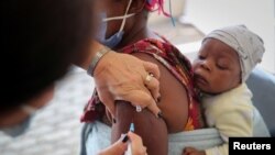 Un trabajador de la salud administra la vacuna contra la enfermedad por coronavirus a una mujer, en medio de la propagación de la variante Ómicron del SARS-CoV-2 en Johannesburgo, Sudáfrica, el 4 de diciembre de 2021.