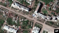 This satellite image provided by Maxar Technologies shows the aftermath of artillery bombardments in Popasna, a town in Sievierodonetsk Raion, Ukraine, May 25, 2022. Russian forces continue shelling Sievierodonetsk this week.