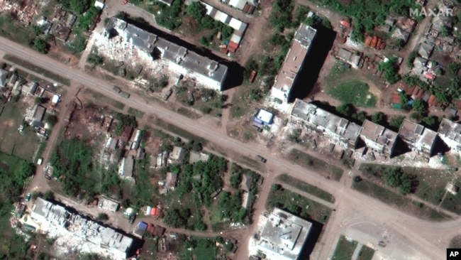 This satellite image provided by Maxar Technologies shows a Russian armor unit deployed along a road and the aftermath of artillery bombardments in Popasna, a town in Sievierodonetsk Raion, May 25, 2022. (Satellite image ©2022 Maxar Technologies via AP)