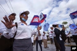 FILE - Cambodia's Candlelight Party supporters celebrate their dancing before marching during an election campaign for the June 5 communal elections in Phnom Penh, Cambodia, Saturday, May 21, 2022.