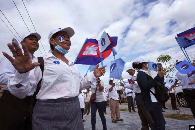 FILE - Cambodia's Candlelight Party supporters celebrate their dancing before marching during an election campaign for the June 5 communal elections in Phnom Penh, Cambodia, Saturday, May 21, 2022.