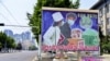 Sebuah papan iklan menggambarkan pengiriman produk-produk medis di sebuah jalan yang sepi di tengah ketakutan penyebaran COVID-19 di Pyongyang, Korea Utara. Foto dirilis oleh kantor berita Kyodo pada 23 Mei 2022. (Foto: Kyodo via Reuters)