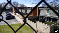 Cars are parked in front of a housing complex, in Providence, RI, April 11, 2022.