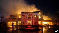 Firefighters work to put out a structure burning during a wildfire May 11, 2022, in Laguna Niguel, Calif.