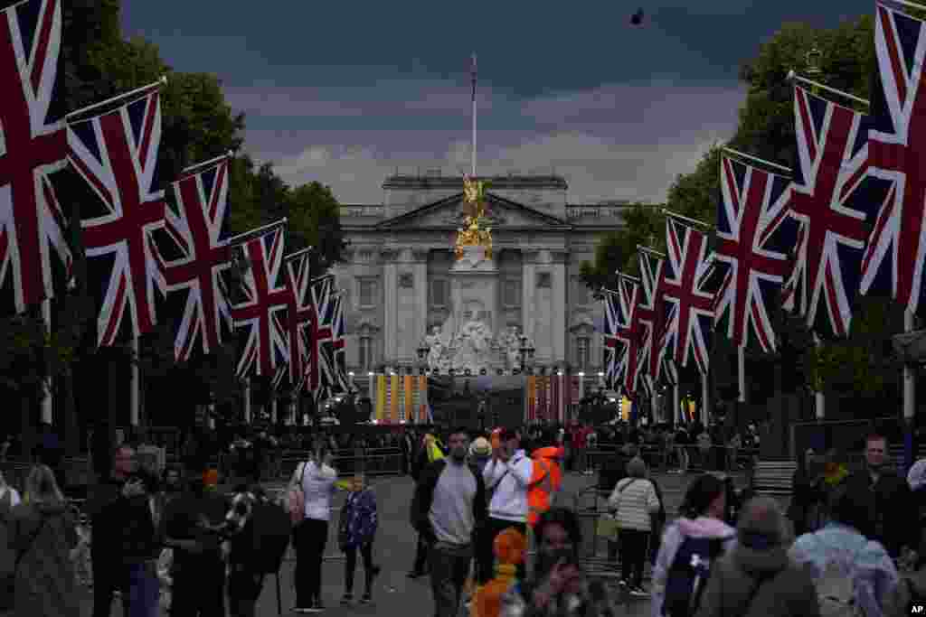 People look at the Buckingham Palace and the Queen Victoria Memorial statue as the road is lined with Union flags and closed to traffic ahead of Britain&#39;s Queen Elizabeth II&#39;s Platinum Jubilee, in London.