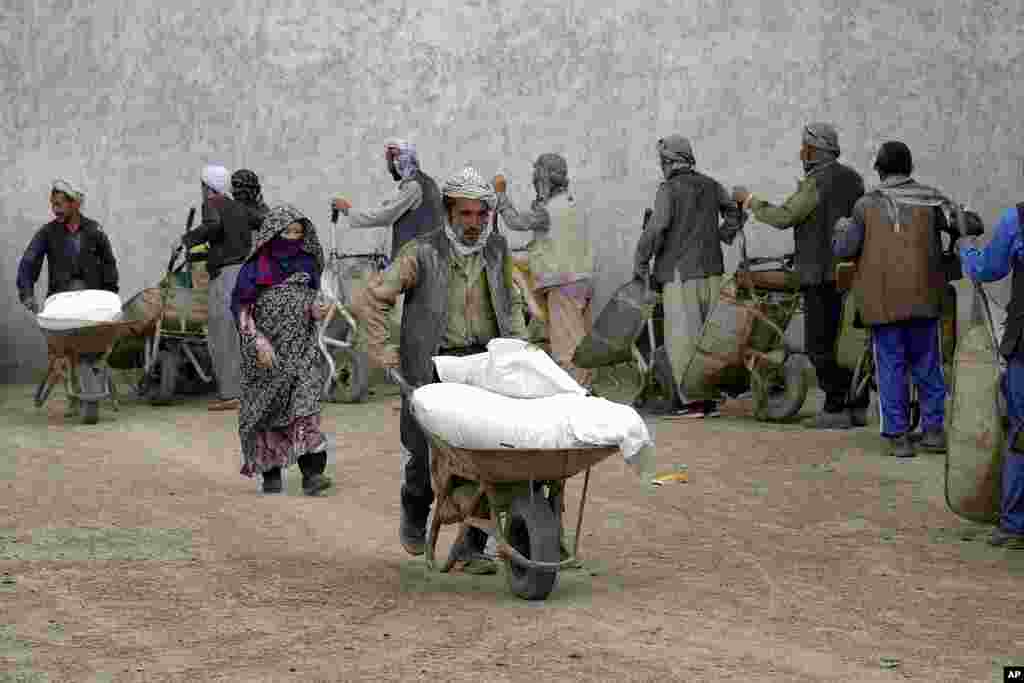 People receive food rations distributed by a South Korea humanitarian aid group, in Kabul, Afghanistan.