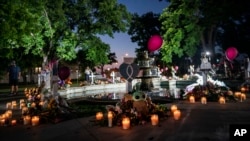 Candles are lit at dawn on May 27, 2022, at a memorial site in the town square for the victims killed in this week's elementary school shooting in Uvalde, Texas. 