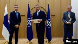 Đại sứ Phần Lan tại NATO Klaus Korhonen, Tổng thư ký NATO Jens Stoltenberg và Đại sứ Thụy Điển tại NATO Axel Wernhoff tham dự buổi lễ đánh dấu việc Thụy Điển và Phần Lan đăng ký trở thành thành viên NATO tại Brussels, Bỉ, ngày 18 tháng 5 năm 2022.