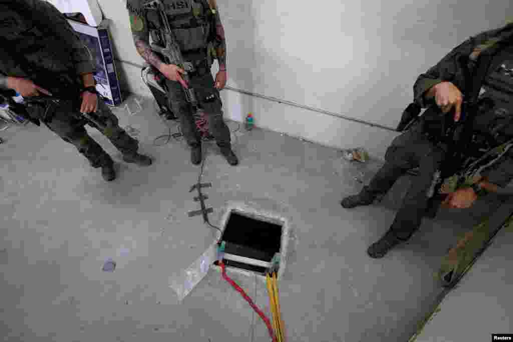 Agentes federales del Departamento de Seguridad Nacional permanecen parados junto a la apertura de un túnel en EEUU dentro de un almacén después de que la oficina del fiscal de EEUU anunciara el descubrimiento de un túnel subterráneo desde México, cerca de la frontera en San Diego, California.