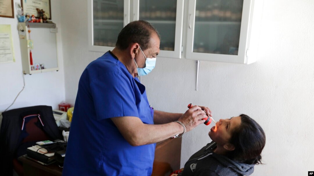 FILE - A doctor examines a patient in his office in the Iztapalapa neighborhood of Mexico City, Feb. 6, 2021. 