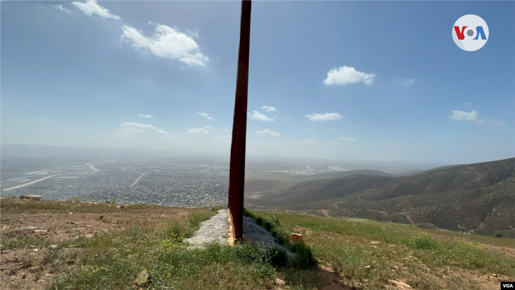 La barrera física de la frontera se impone en el sector de San Diego donde a la derecha de esta imagen resalta el terreno montañoso y poco poblado en California, mientras a la izquierda se ve la ciudad de Tijuana, México. Foto: Celia Mendoza, 11 de abril de 2022, frontera EEUU-México.