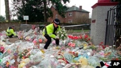 FILE - A police officer arranges bouquets of flowers in rows at a side entrance to Dunblane Primary School in Dunblane, Scotland, March 15, 1996. A 1996 school shooting that killed 16 children in Dunblane was Britain's deadliest school shooting — and also the only one.