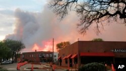 FILE - A sunset is seen through plumes of wildfire smoke in Las Vegas, New Mexico, on Saturday, May 7, 2022. 