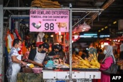 Seorang pelanggan menunggu untuk membeli daging ayam di pasar basah di Kuala Lumpur pada 1 September 2021. (Foto: AFP)