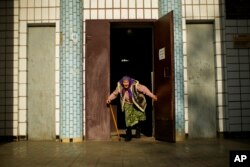 A woman, fleeing from an area near the front line in Donetsk, prepares to board a bus in Kurakhove, eastern Ukraine, May 23, 2022. In the Donbas region, people continue to flee from towns and villages coming under heavy bombardment.