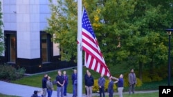 Співробітники посольства США в Україні підняли державний прапор США на будівлі посольства США, середа, 18 травня 2022 року. (AP Photo/Єфрем Лукацький)