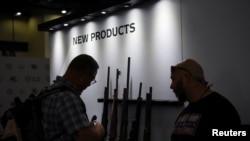 People look at a gun exhibit during the National Rifle Association (NRA) annual convention in Houston, Texas, U.S., May 27, 2022. REUTERS/Callaghan O'Hare