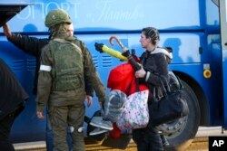 Una mujer abandona un refugio cerca a una planta metalúrgica en Mariúpol.