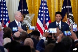 FILE - President Joe Biden, left, listens as Talib M. Shareef, President and Imam of Masjid Muhammad in Washington, speaks during a reception to celebrate Eid al-Fitr, in the East Room of the White House in Washington, May 2, 2022.