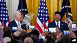 FILE - President Joe Biden, left, listens as Talib M. Shareef, President and Imam of Masjid Muhammad in Washington, speaks during a reception to celebrate Eid al-Fitr, in the East Room of the White House in Washington, May 2, 2022.