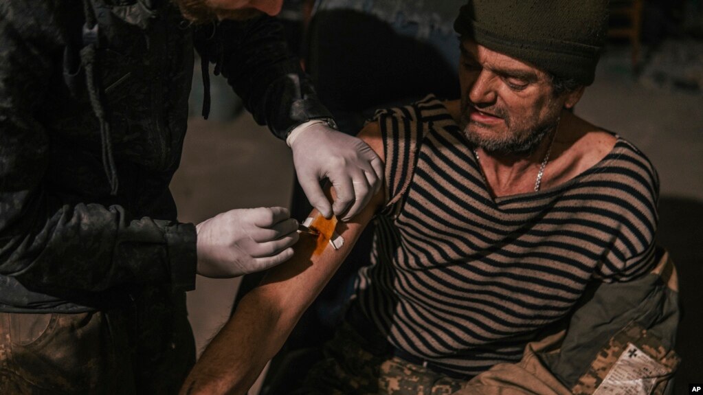 在乌克兰国民警卫队新闻办公室亚速特种部队团提供的这张照片中，亚速特种部队的一名军人于 2022 年 5 月 10 日在乌克兰马里乌波尔的亚速钢铁厂内接受治疗。(photo:VOA)