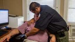 El agente David Valdez abraza al juez de paz de Uvalde, Eulalio Díaz, mientras Díaz cuenta que tuvo que identificar los cuerpos en Uvalde, Texas, el 25 de mayo de 2022. 