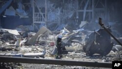Un bombero ucraniano trabaja cerca de un edificio destruido a las afueras de Odesa, Ucrania, el martes 10 de mayo de 2022. El ejército ucraniano dijo que las fuerzas rusas habían lanzado siete misiles el lunes contra el crucial puerto de Odesa, en el Mar 