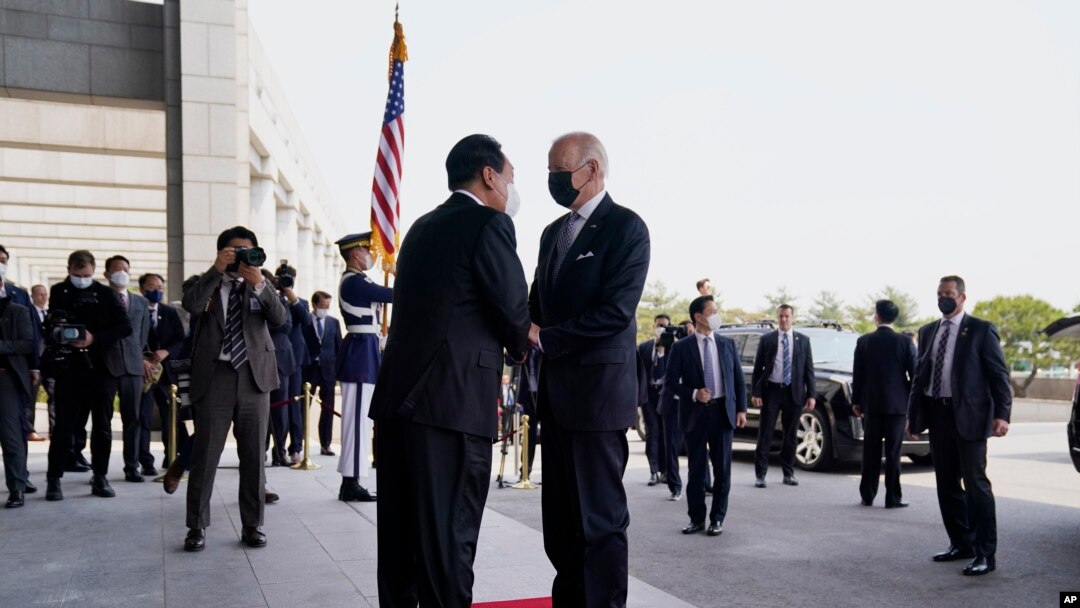 U.S. President Joe Biden, right, shakes hands with South Korean President Yoon Suk Yeol at the People's House, May 21, 2022, in Seoul. 