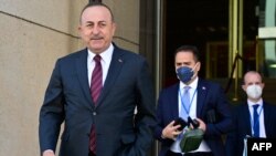 Turkish Foreign Minister Mevlut Cavusoglu, left, walks out of the building during a break of an informal meeting of NATO Foreign Ministers on the conflict in Ukraine on May 15, 2022, in Berlin.