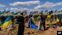 Гробарі опускають труну українського військовослужбовця Олександра Матюхіна, 32 роки, у Харкові, на сході України, 23 травня 2022 року.
