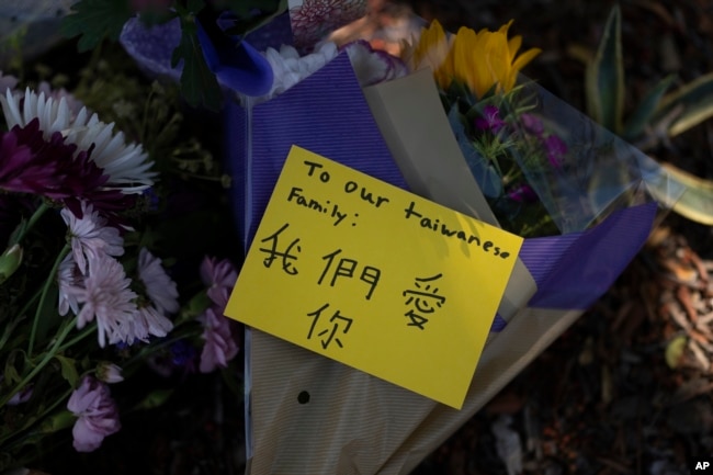 Flowers and a message honoring the victims in Sunday's shooting at Geneva Presbyterian Church are placed outside the church in Laguna Woods, Calif., Monday, May 16, 2022. (AP Photo/Jae C. Hong)