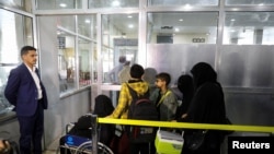 People queue at the departures lounge to board the first commercial flight to be operated from Sanaa Airport, in Sanaa, Yemen, May 16, 2022.