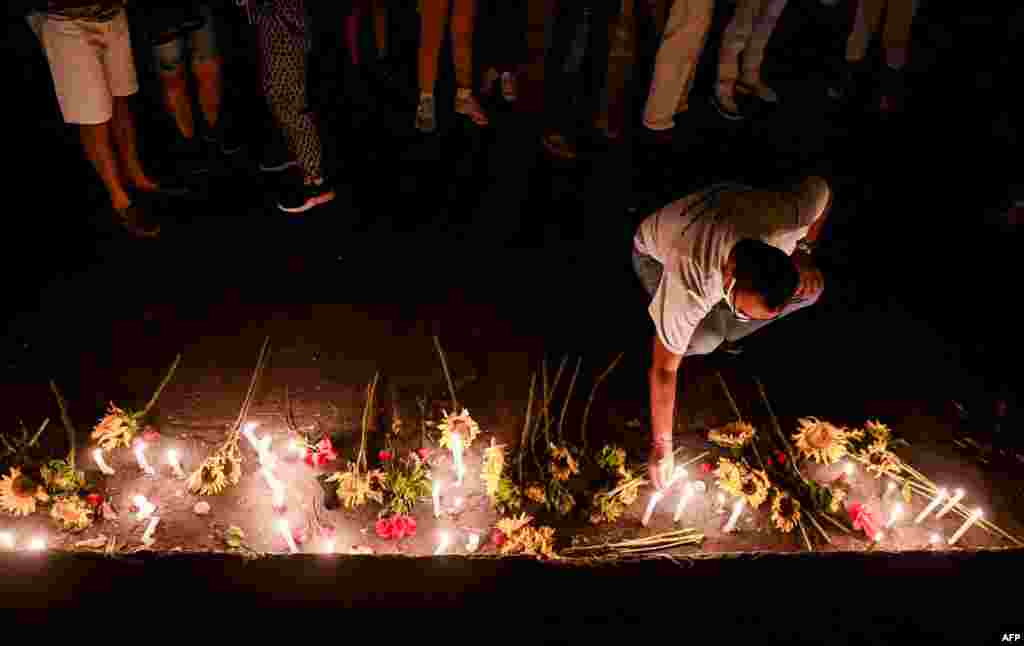 Un hombre enciende una vela durante una vigilia por las víctimas del accidente del Hotel Saratoga en La Habana, el 13 de mayo de 2022.