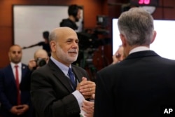 Former Federal Reserve Chairman Ben Bernanke, left, talks to Federal Reserve Chairman Jerome Powell on June 4, 2019, in Chicago.