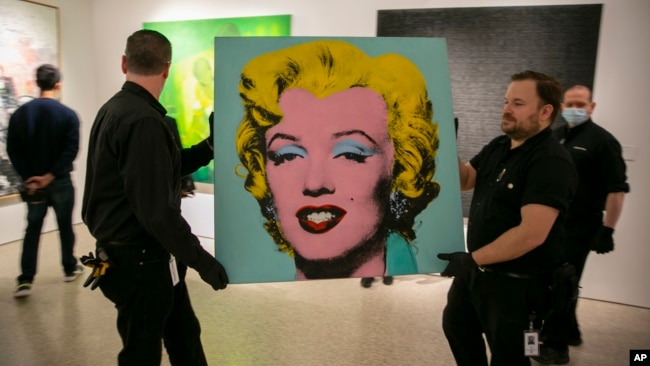 The 1964 silk-screen image, "Shot Sage Blue Marilyn," by Andy Warhol is carried in Christie's showroom in New York, Sunday, May 8, 2022. The image sold for $195 million, Monday, May 9. (AP Photo/Ted Shaffrey, File)