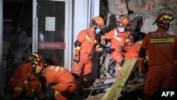 這張照片拍攝於2022年4月29日，顯示救援人員在中國中部湖南省長沙市一棟倒塌的六層建築中在搜尋倖存者。