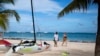 Turistas disfrutan de una playa en Punta Cana en República Dominicana, el 7 de enero de 2022. - Casi 5 millones de turistas visitaron República Dominicana en 2021, en comparación con los 6,4 millones reportados en 2019 antes de que comenzara la pandemia. [AFP]