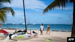 Turistas disfrutan de una playa en Punta Cana en República Dominicana, el 7 de enero de 2022. - Casi 5 millones de turistas visitaron República Dominicana en 2021, en comparación con los 6,4 millones reportados en 2019 antes de que comenzara la pandemia. [AFP]