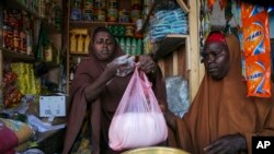 Halimo Hersi, 42, right, buys wheat flour from a shopkeeper in the Hamar-Weyne market in the capital Mogadishu, Somalia Thursday, May 26, 2022. Families across Africa are paying about 45% more for wheat flour as Russia's war in Ukraine blocks exports from the Black Sea.
